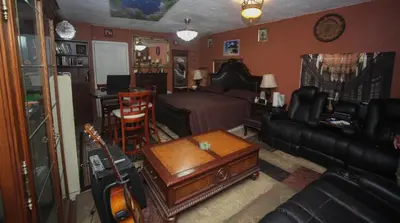 a living room with a bed and a room with a guitar at Beautiful large bedroom in Orlando