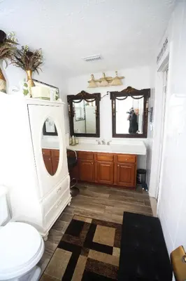 a bathroom with a toilet and a sink and mirrors at Beautiful large bedroom in Orlando
