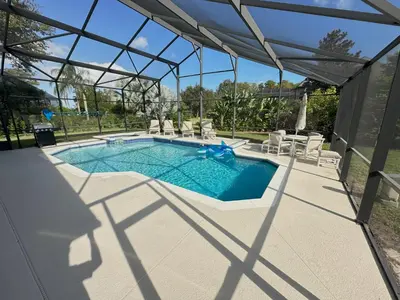 a swimming pool with a pergola and chairs around it at Mickeys Palm - Brand New! 6BR Modern with Private Pool Hot Tub BBQ Home Theater - 2 Miles to Disney in Orlando