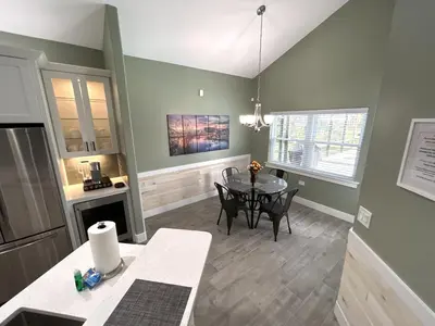 a kitchen with a table and a dining room at Mickeys Palm - Brand New! 6BR Modern with Private Pool Hot Tub BBQ Home Theater - 2 Miles to Disney in Orlando