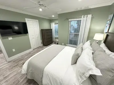 a bedroom with a large bed and a window at Mickeys Palm - Brand New! 6BR Modern with Private Pool Hot Tub BBQ Home Theater - 2 Miles to Disney in Orlando