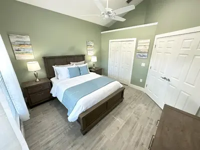 a bedroom with a bed and two white doors at Mickeys Palm - Brand New! 6BR Modern with Private Pool Hot Tub BBQ Home Theater - 2 Miles to Disney in Orlando