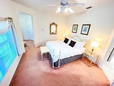 a bedroom with a bed and a large window at Mickeys Homestead - Stylish 4BR Lakefront Cottage with Huge South Facing Pool Hot Tub BBQ - 2 miles Disney! in Orlando