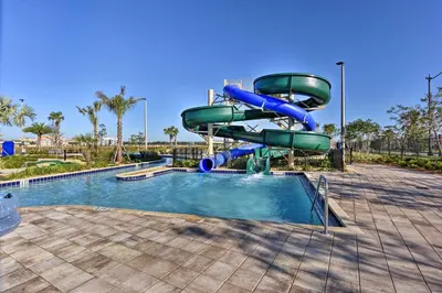 a water slide in a park with a pool at Kissimmee Condo about 10 Mi to Disney Attractions in Kissimmee
