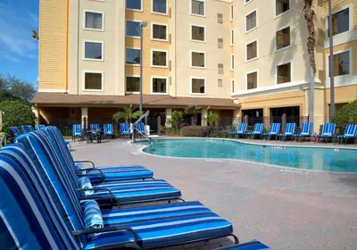 a group of blue lounge chairs next to a building at staySky Suites I-Drive Orlando Near Universal in Orlando