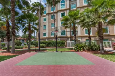a basketball court in front of a building with palm trees at Hawthorn Extended Stay by Wyndham Orlando in Orlando