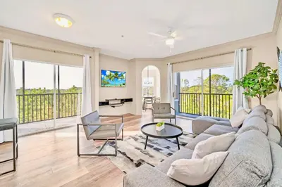 a living room with a couch and a table at Spacious 3BR Condo with Pool, near Disney! in Orlando