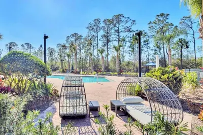 a patio with two chairs and a pool at Spacious 3BR Condo with Pool, near Disney! in Orlando