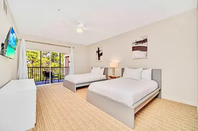 a bedroom with two beds and a balcony at Spacious 2BR Condo with Pool , near Disney! in Orlando