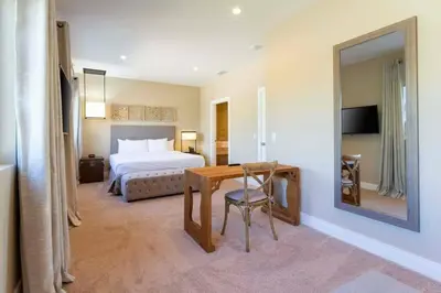 a hotel room with a bed and a table and a mirror at Beautiful Magic Village 4 Suites near Disney 7493 in Orlando