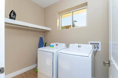 a laundry room with a washer and dryer and a window at Beautiful Magic Village 4 Suites near Disney 7493 in Orlando