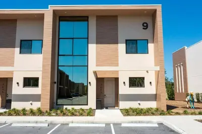 a building with large glass windows in a parking lot at Beautiful Magic Village 4 Suites near Disney 7493 in Orlando