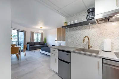 a kitchen with a sink and a living room at Spacious Studio close to Theme Parks in Orlando