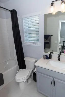 a white bathroom with a toilet and a sink at Pet Friendly Modern Zen Studio Retreat with Hot Tub! home in Orlando