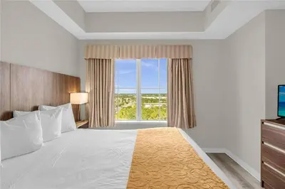 a bedroom with a large bed with a large window at Premier Resort Condos Near Disney & Universal in Orlando