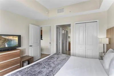 a bedroom with a bed and a flat screen tv at Premier Resort Condos Near Disney & Universal in Orlando