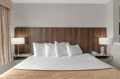 a bedroom with a large white bed with two lamps at Premier Resort Condos Near Disney & Universal in Orlando