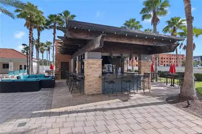 a patio with a bar and chairs and palm trees at Premier Resort Condos Near Disney & Universal in Orlando