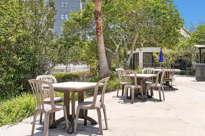 a row of tables and chairs sitting on a sidewalk at Cozy Condo on International Dr. Near Universal Studios in Orlando