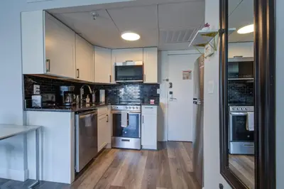 a kitchen with white appliances and wooden floors at Cozy Condo on International Dr. Near Universal Studios in Orlando