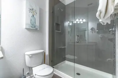 a bathroom with a toilet and a glass shower at 2821 Windsor Hills in Orlando