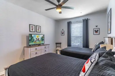a bedroom with two beds and a flat screen tv at 2821 Windsor Hills in Orlando