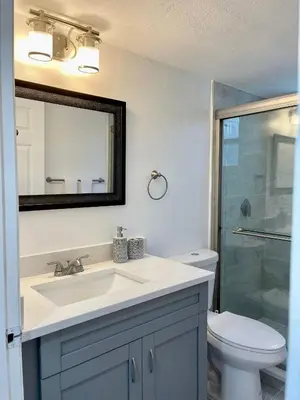a bathroom with a sink and a toilet and a mirror at Grand Family 3BR Condo Apartment near Disney Parks in Kissimmee