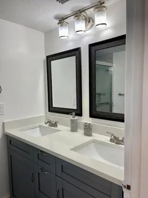 a bathroom with two sinks and two mirrors at Grand Family 3BR Condo Apartment near Disney Parks in Kissimmee