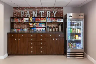 a refrigerator and cabinets in a room with drinks at Four Points by Sheraton Orlando Convention Center in Orlando