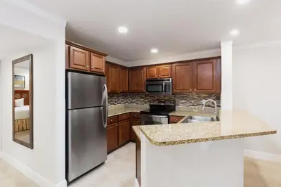 a kitchen with wooden cabinets and a stainless steel refrigerator at Westgate Blue Tree Resort in Orlando