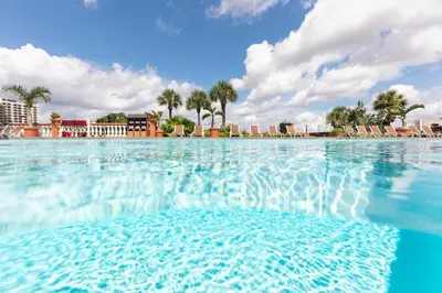 a large pool of water with chairs and palm trees at Westgate Palace Hotel - Universal - I-Drive in Orlando