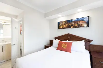 a bedroom with a white bed and a painting on the wall at Westgate Palace Hotel - Universal - I-Drive in Orlando
