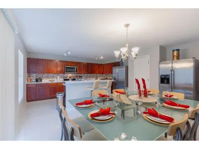a kitchen with a dining table with red napkins on it at Best place to unwind and have lots of fun! in Kissimmee