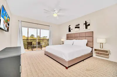 a bedroom with a bed and a balcony at Upstay Condo with Outdoor Pool & Sauna in Orlando