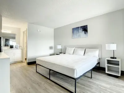 a bedroom with a large bed and a kitchen at Stayable Kissimmee West in Kissimmee