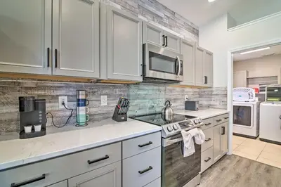 a kitchen with white cabinets and white appliances at 5 Mi to Disney World Retreat with Pool and Lanai! in Kissimmee