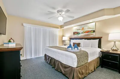 a bedroom with a large bed with a ceiling fan at Silver Lake Resort in Orlando
