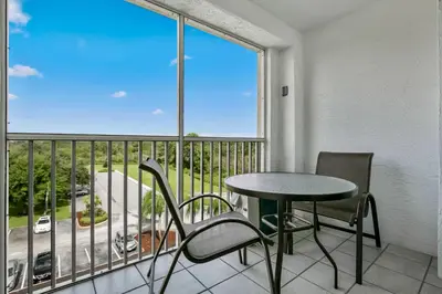 a balcony with a table and chairs and a window at Silver Lake Resort in Orlando
