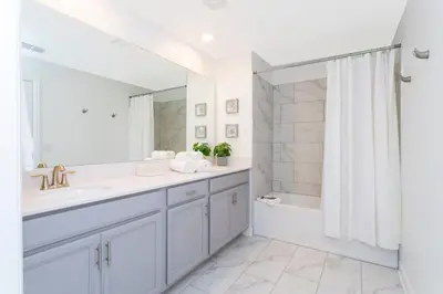 a bathroom with a sink and a tub and a mirror at Wonderful 5 Bd Close to Disney @ Storey Lake Resort 2980 in Kissimmee