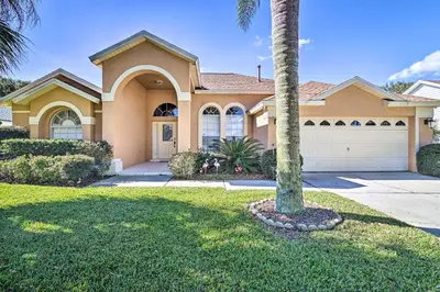 a palm tree in front of a house at No Pet Fee! Snowbird Haven in Lake Worth Beach! in Orlando
