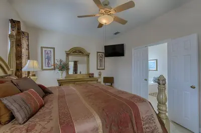 a bedroom with a large bed with a ceiling fan at Resort 5 Bed Private Pool & Spa, Game Room Home villa in Kissimmee