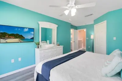 a blue bedroom with a bed and a ceiling fan at Disney Area 4 bed 3,5 Bathroom Emerald Island townhouse in Kissimmee
