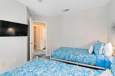 a bedroom with two beds and a flat screen tv at Disney Area 4 bed 3,5 Bathroom Emerald Island townhouse in Kissimmee