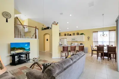 a living room with a couch and a dining room at Fantastic Resort 5BR House - South Facing Pool Spa villa in Kissimmee
