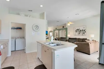 a kitchen and living room with a sink and a couch at 4 Bedroom 3 Bath South Facing Pool Spa Villa villa in Kissimmee