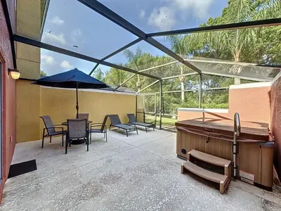 a patio with a table and chairs and an umbrella at Amazing Townhouse close to Disney 2 Bed 2,5 Bath townhouse in Kissimmee