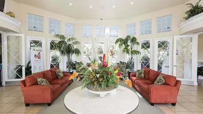 a living room with two couches and a table with flowers at Windsor Palms 3 bed Condo in Gated Resort condo in Kissimmee