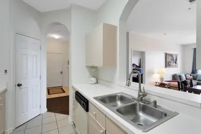 a kitchen with a sink and a living room at Windsor Palms 3 bed Condo in Gated Resort condo in Kissimmee