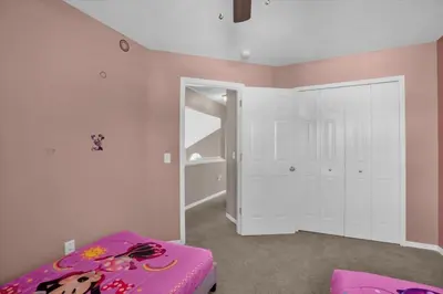 a bedroom with a pink room with a bed and a door at Elegant Villa Pool Fun Game Room Near Disney in Kissimmee