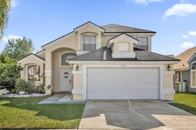 a house with a garage in front of it at Elegant Villa Pool Fun Game Room Near Disney in Kissimmee